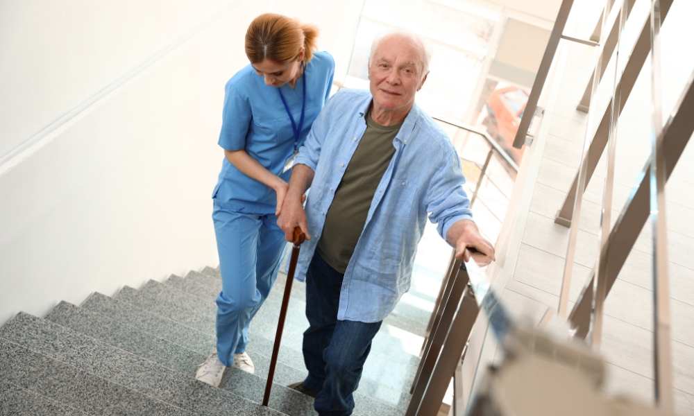 Elderly senior performing balance exercises with healthcare support at home