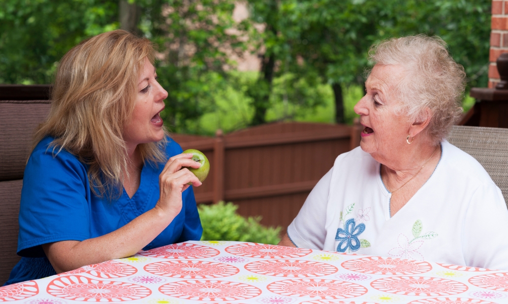 Speech therapist providing in-home speech therapy to a senior patient after stroke recovery